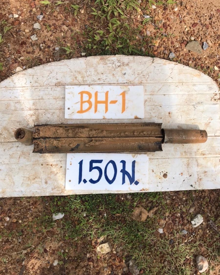 ตัวอย่างดินในกระบอกผ่า วางบนแผ่นไม้ ติดป้าย BH-1 ความลึก 1.50 เมตร